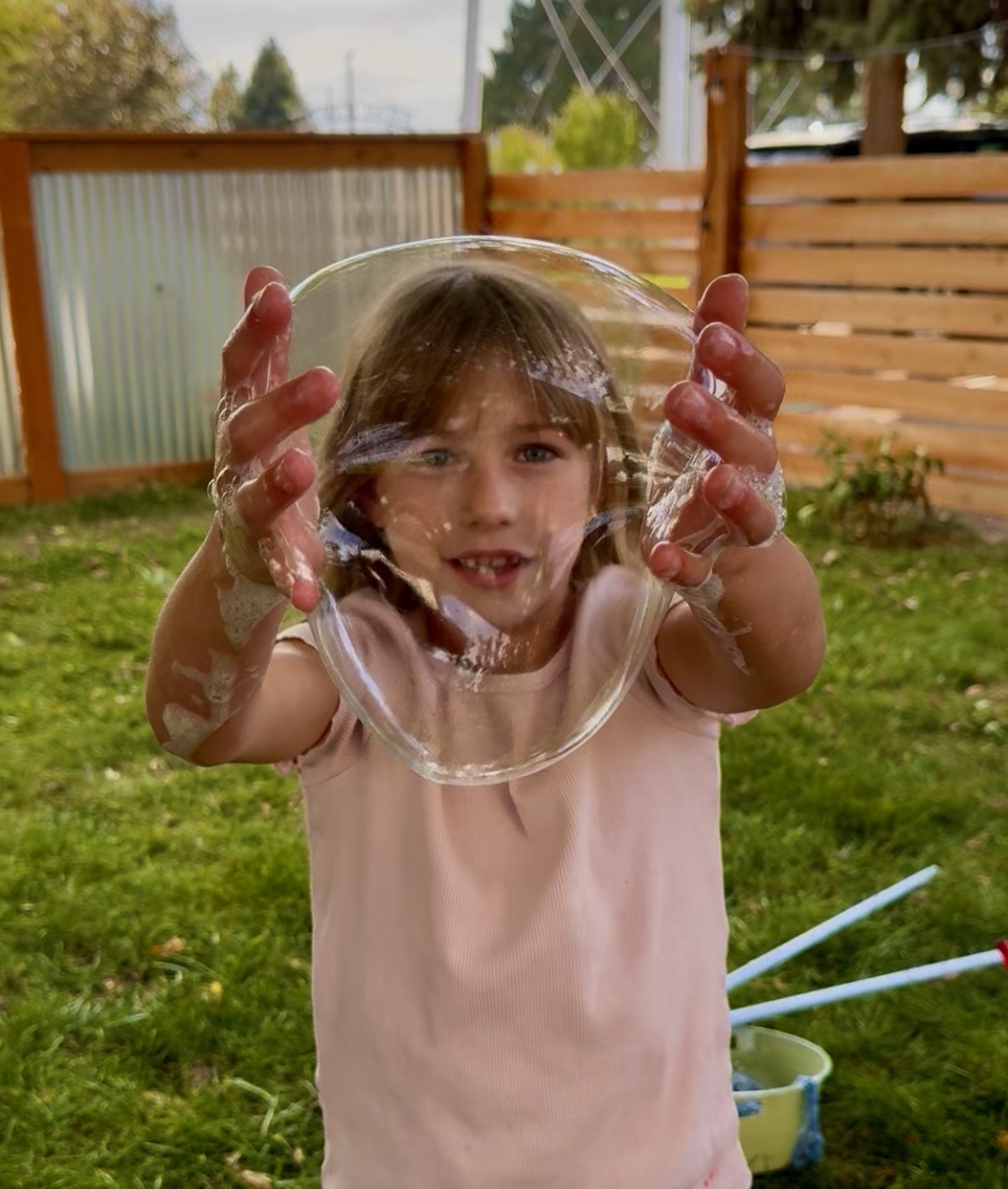 A child holding a shimmering bubble between both hands